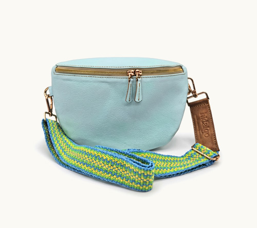 Bolso de cuero color celeste estilo riñonera con correa tejida multicolor